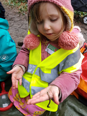 child holding a worm